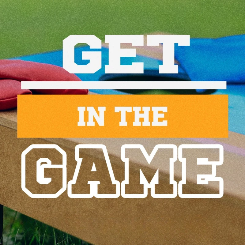 A graphic with the text 'Get in the Game' overlaid on a close-up photo of a cornhole board with red and blue beanbags resting on it in the grass.