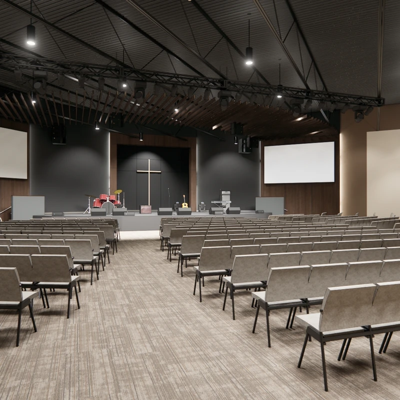 A wide view of an empty, modern church auditorium with rows of chairs facing a stage with a cross, musical instruments, and two large screens.