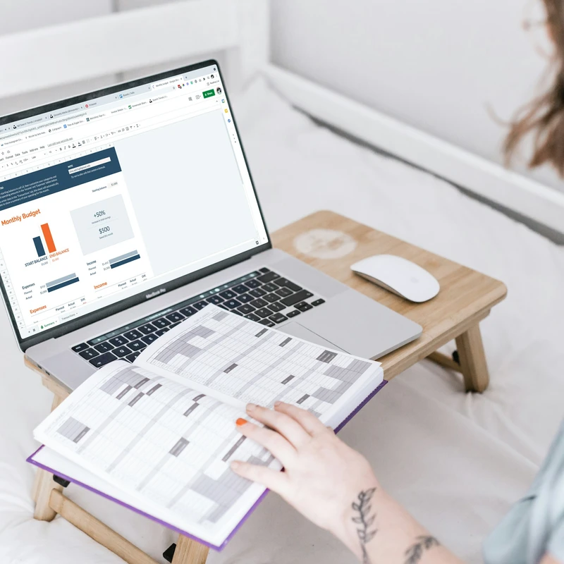 a person sitting on a bed with a laptop