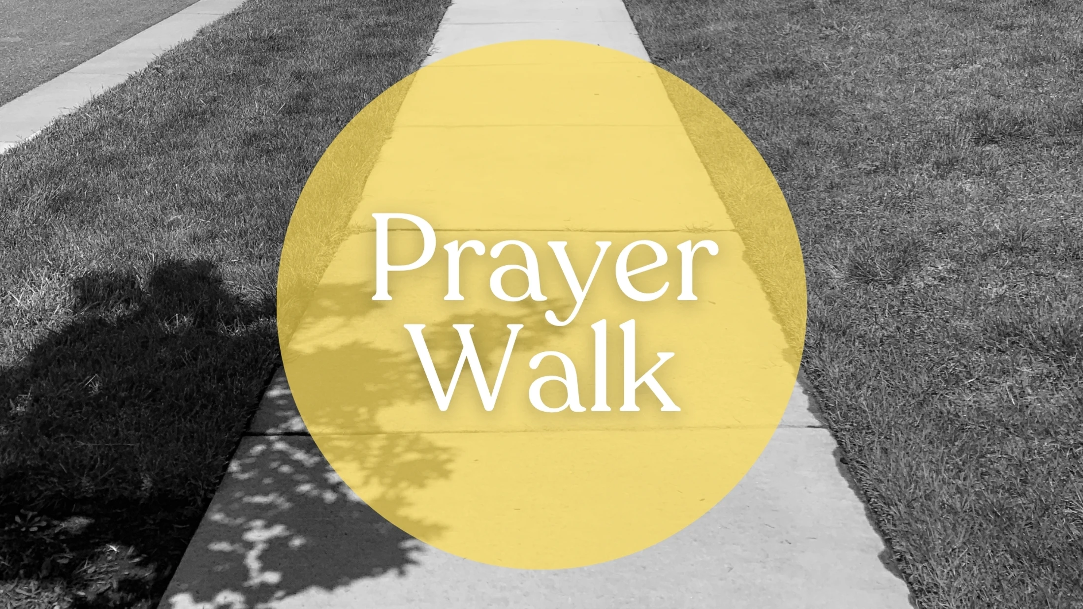 The words 'Prayer Walk' in white serif font inside a yellow circle, overlaid on a black and white photo of a sidewalk and grass.