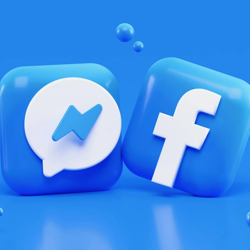 Messenger and Facebook app icons as glossy blue 3D squares on a blue background