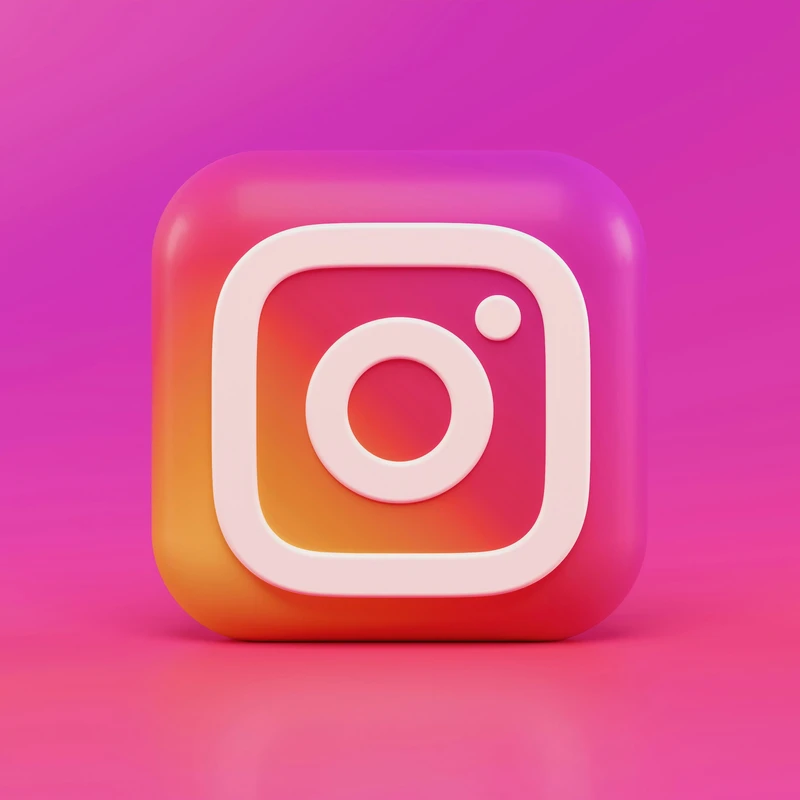 A three-dimensional Instagram logo icon with a pink and orange gradient background