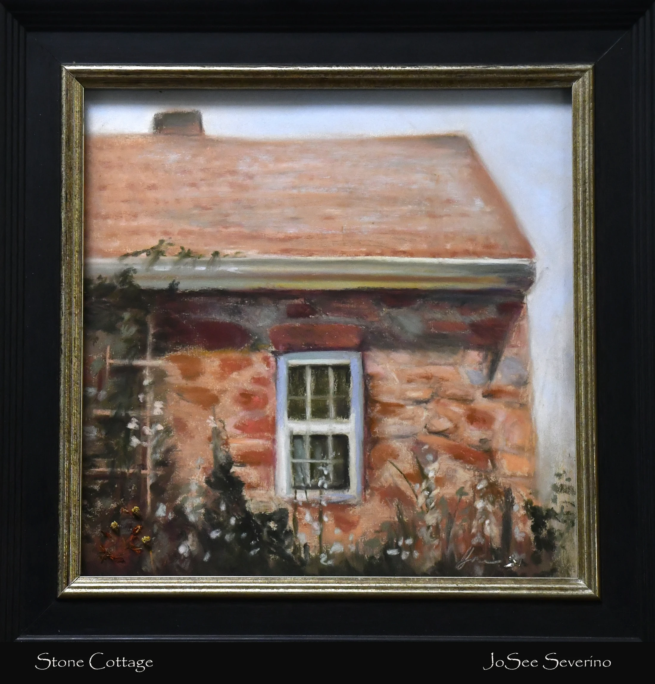 A framed impressionistic painting of a rustic stone cottage with a window. Wildflowers and a ladder are visible in the foreground against the stone wall.