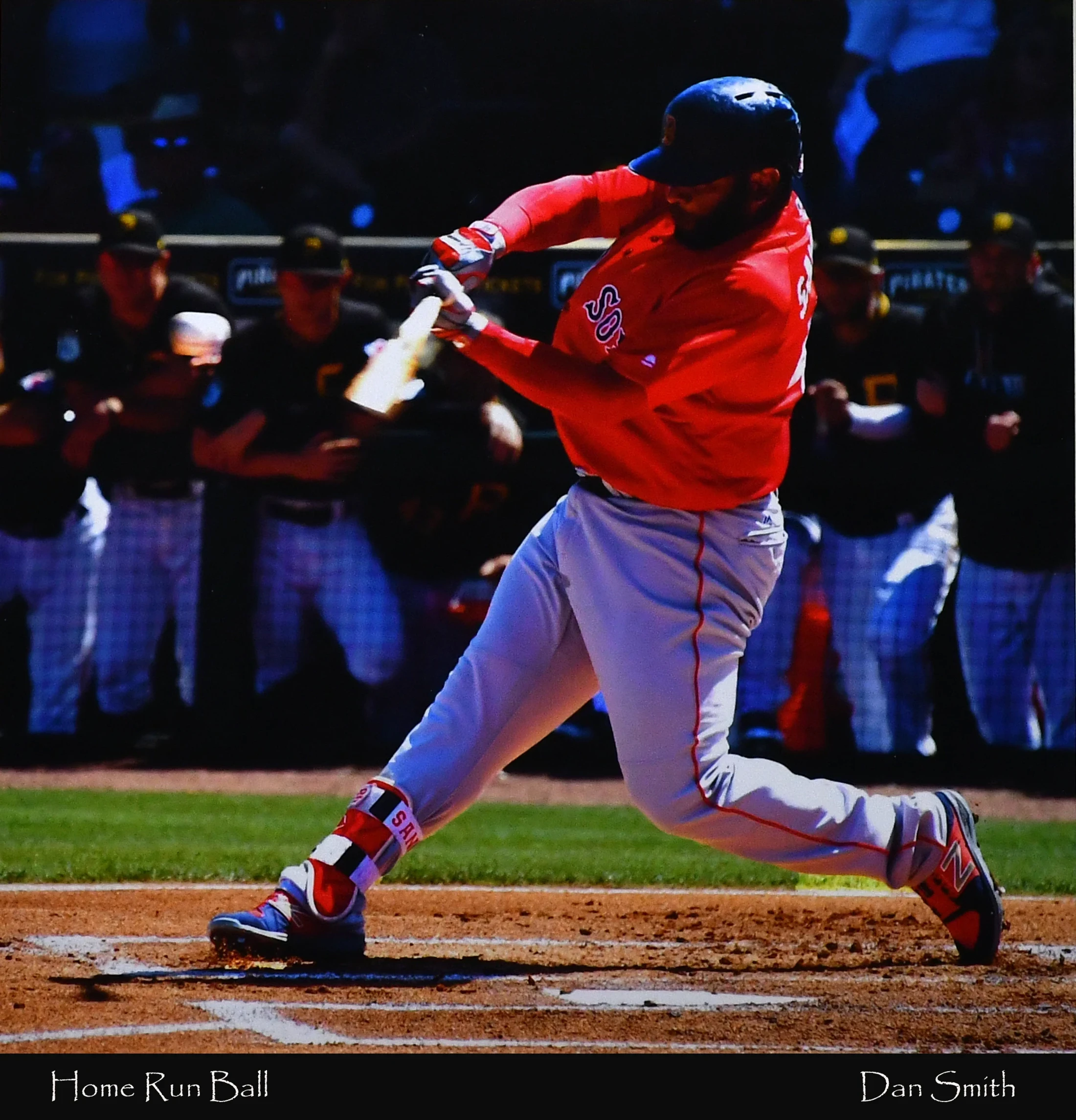 A Boston Red Sox player, Pablo Sandoval, in a red jersey and grey pants, powerfully swings his bat at home plate during a baseball game.