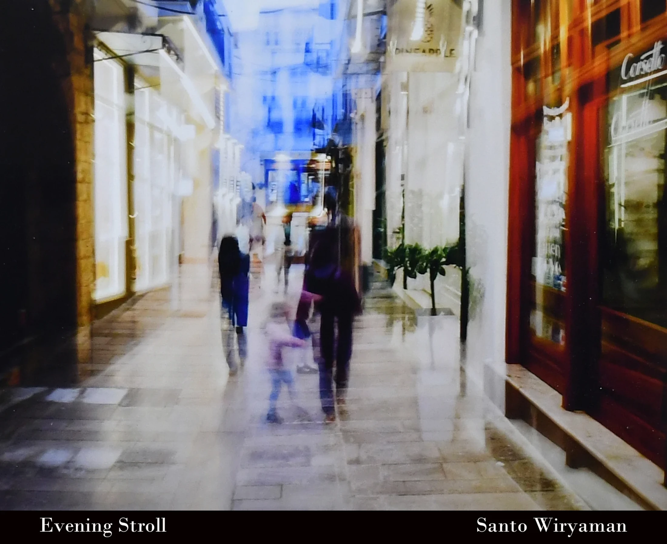 An abstract, long-exposure photo shows blurred figures of people walking down an illuminated alleyway at night, creating a dreamy and ethereal effect.