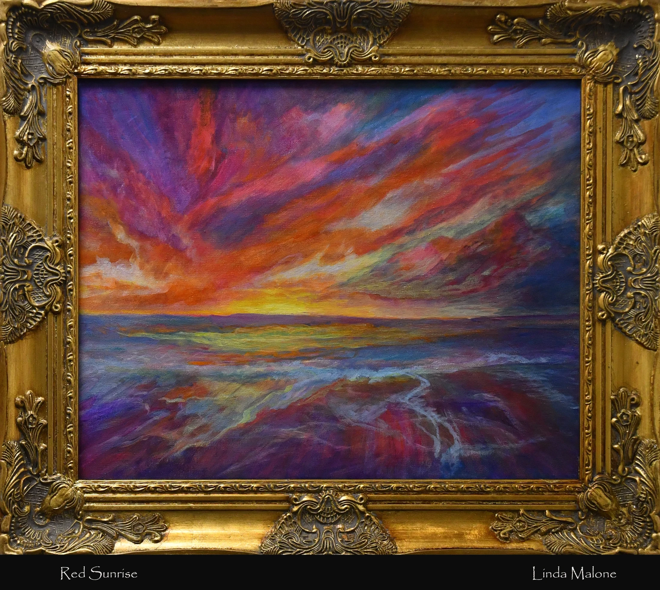 An oil painting of a vibrant red and purple sunrise over the ocean. The colorful sky is reflected in the water, and the piece is in an ornate gold frame.
