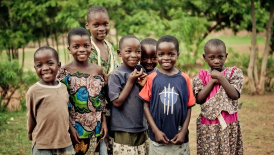 Children supported through World Relief Malawi smile outdoors.