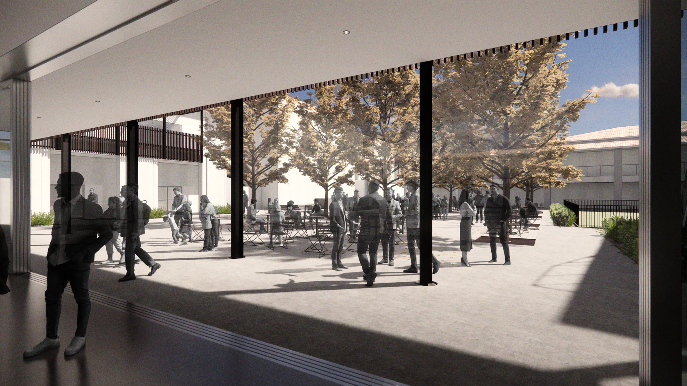 A view from inside a building looking out through glass walls to a sunny courtyard where silhouetted people socialize among trees and outdoor seating.