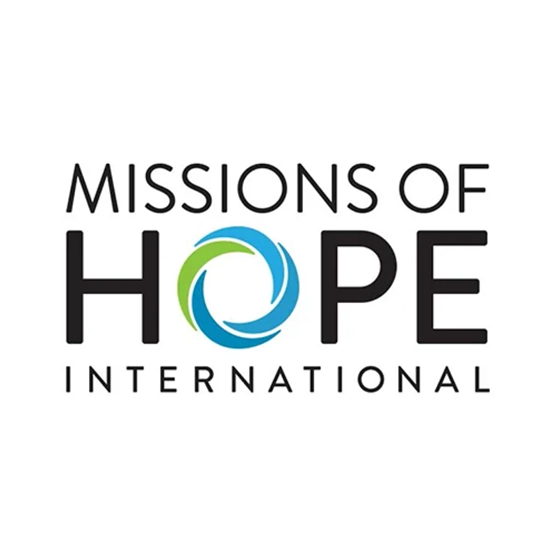 The logo for Missions of Hope International. The O in HOPE is a stylized circle with swirling blue and green shapes, set against a white background.