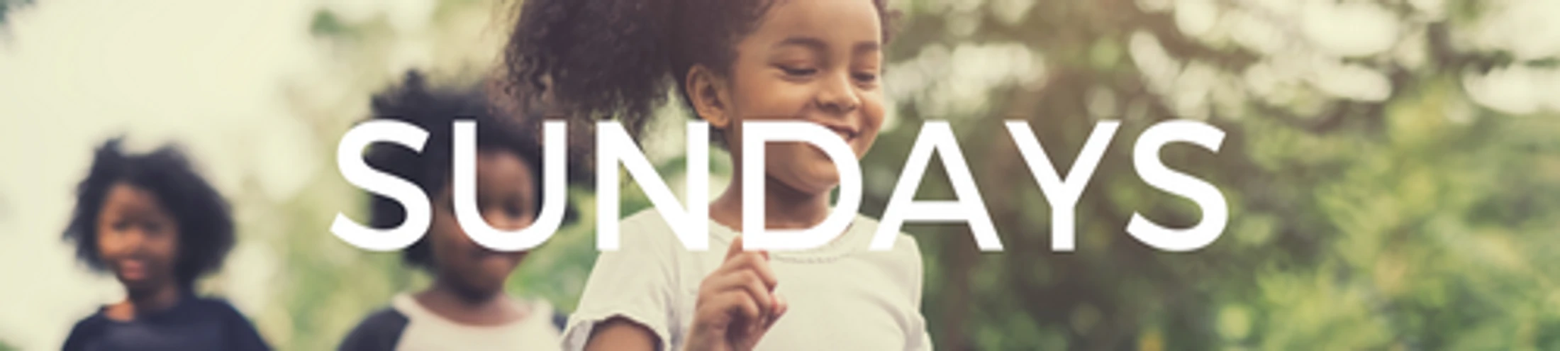 A banner image of three happy Black children running and playing in a park, with the word 'SUNDAYS' in large white letters superimposed in the center.