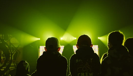 a group of people standing in front of a green light