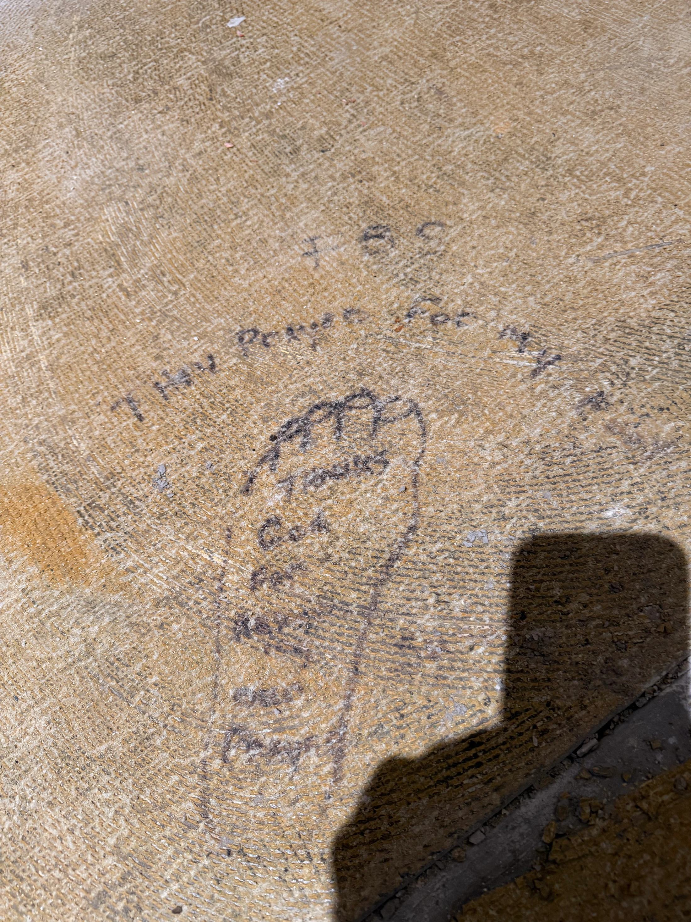 A hand-drawn footprint on a textured stone surface with a prayer of thanks written inside and around it. The text mentions family and God.