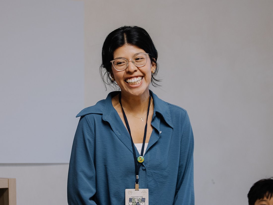 A smiling Discovery Kids Dream Team leader wearing her badge