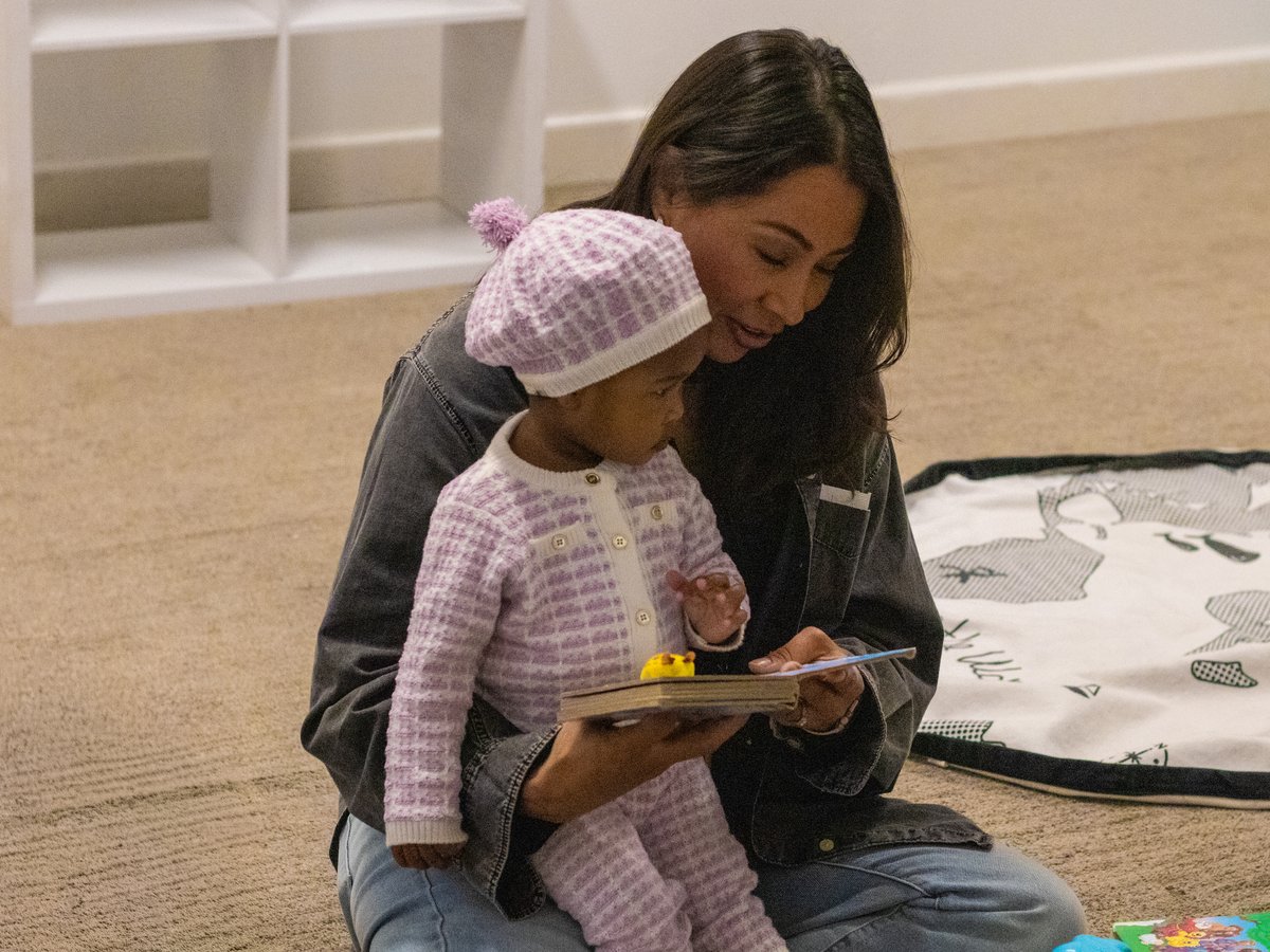 A Discovery Kids leader reading the Bible with a Little Sprouts child