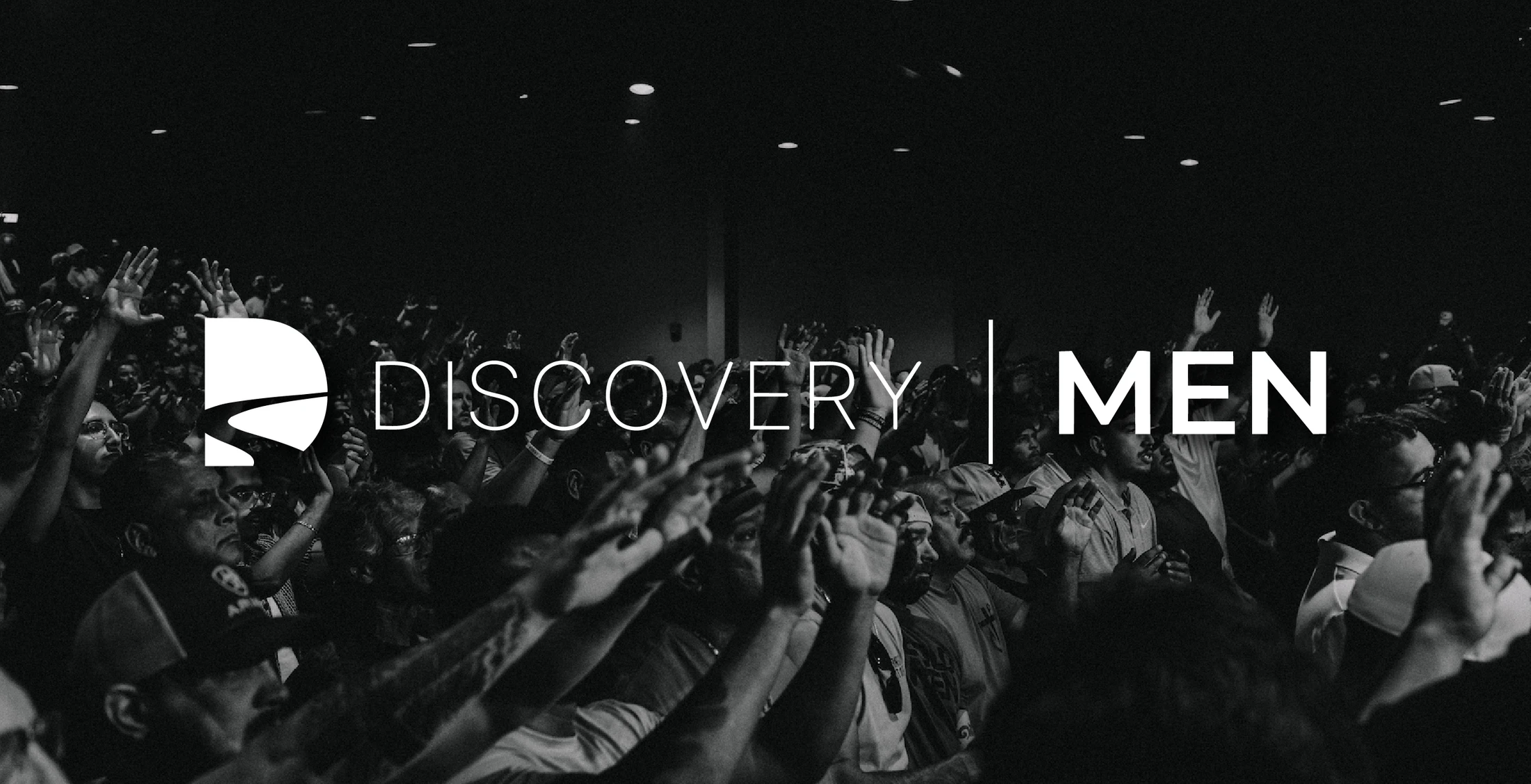 A black and white image of a large crowd of men with their hands raised in worship. The words 'Discovery Men' are overlaid in the center.