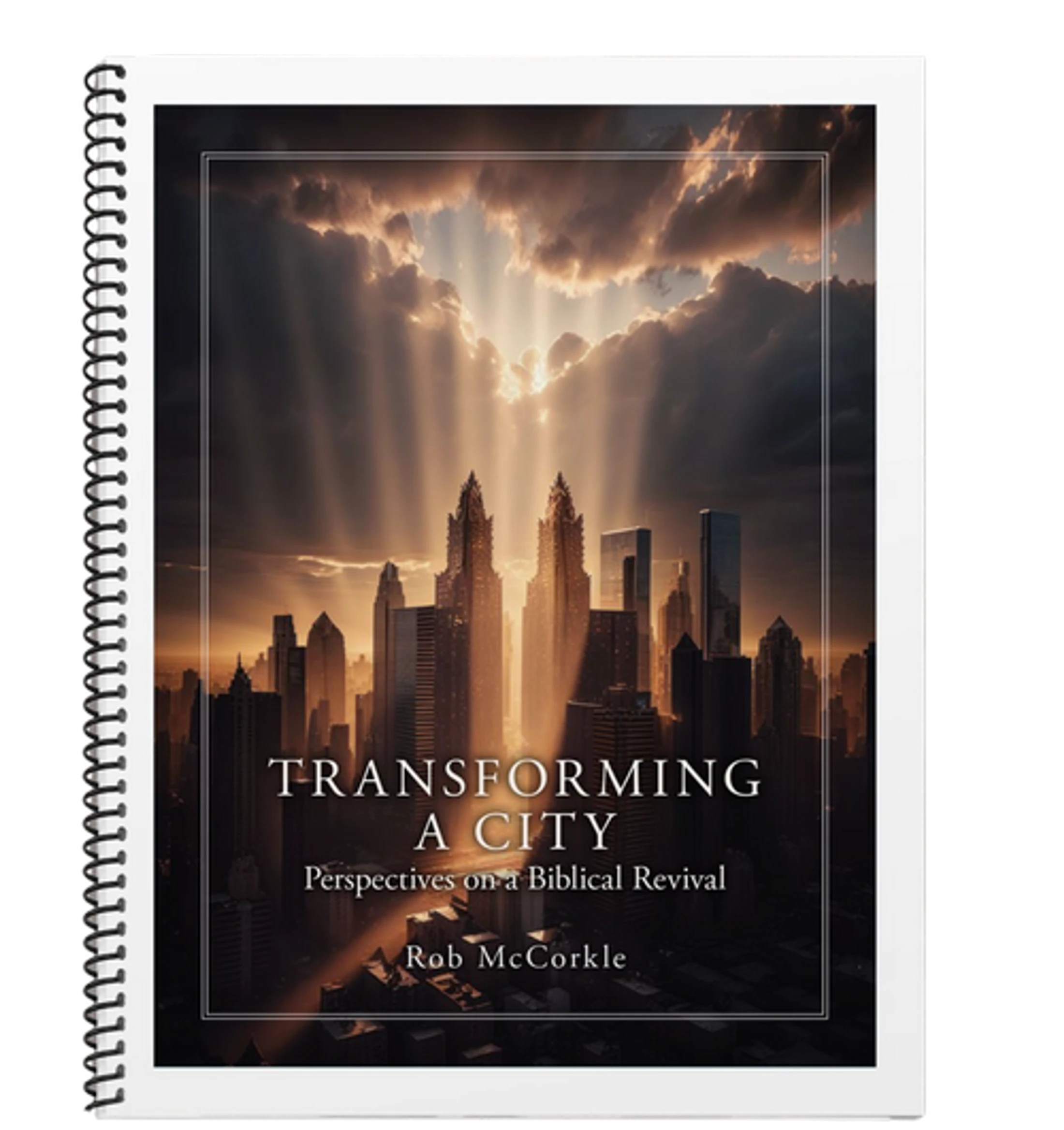The cover of the spiral-bound book 'Transforming a City,' showing a city skyline with dramatic rays of light beaming down from the clouds.