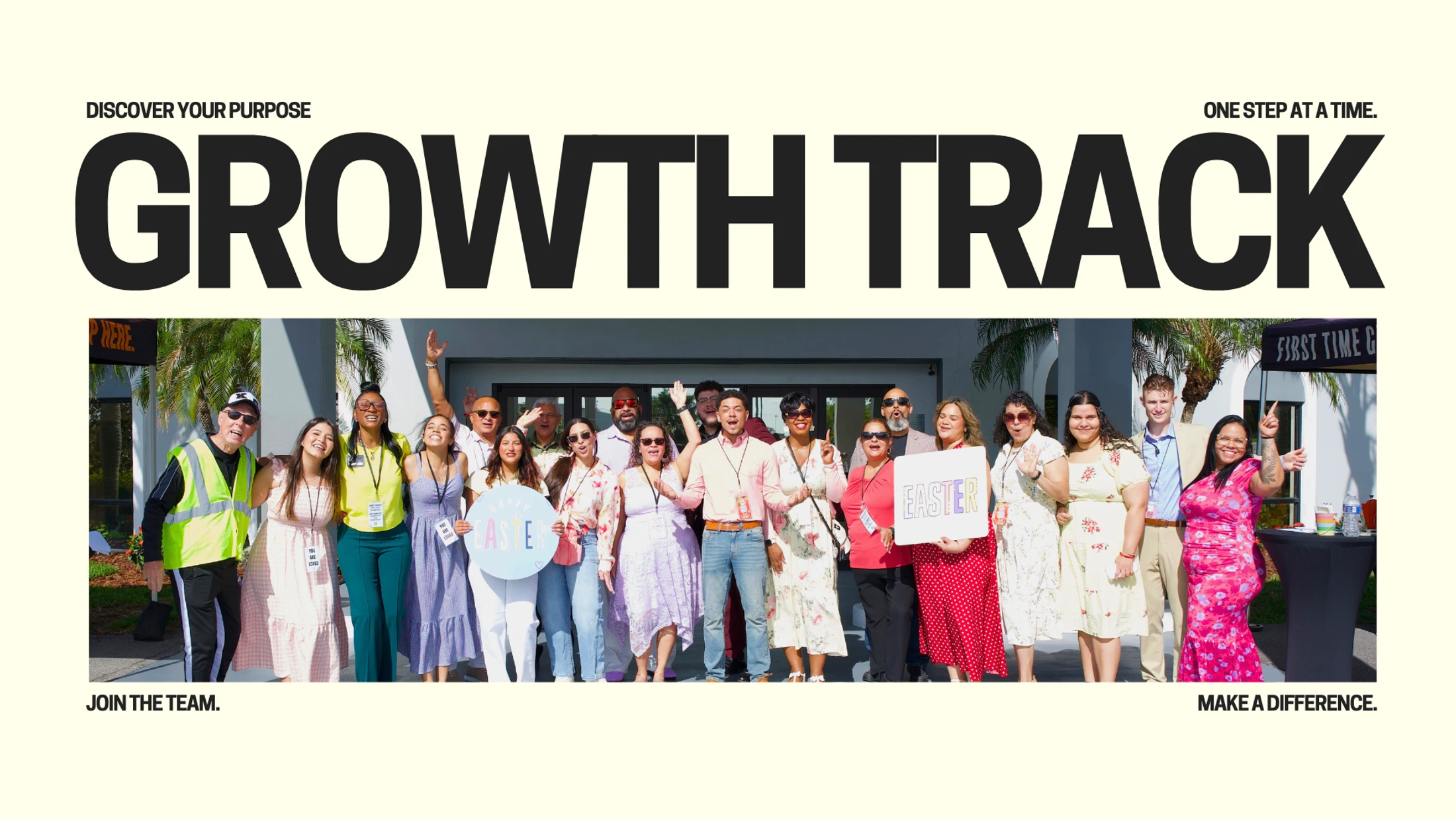 A large, diverse group of smiling volunteers posing for a group photo outside under the words 'Growth Track' in bold text above them.