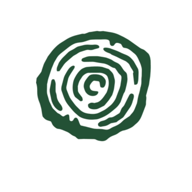 A dark green, hand-drawn symbol on a white background. It's a circular shape with concentric, broken rings forming a spiral or labyrinth pattern.