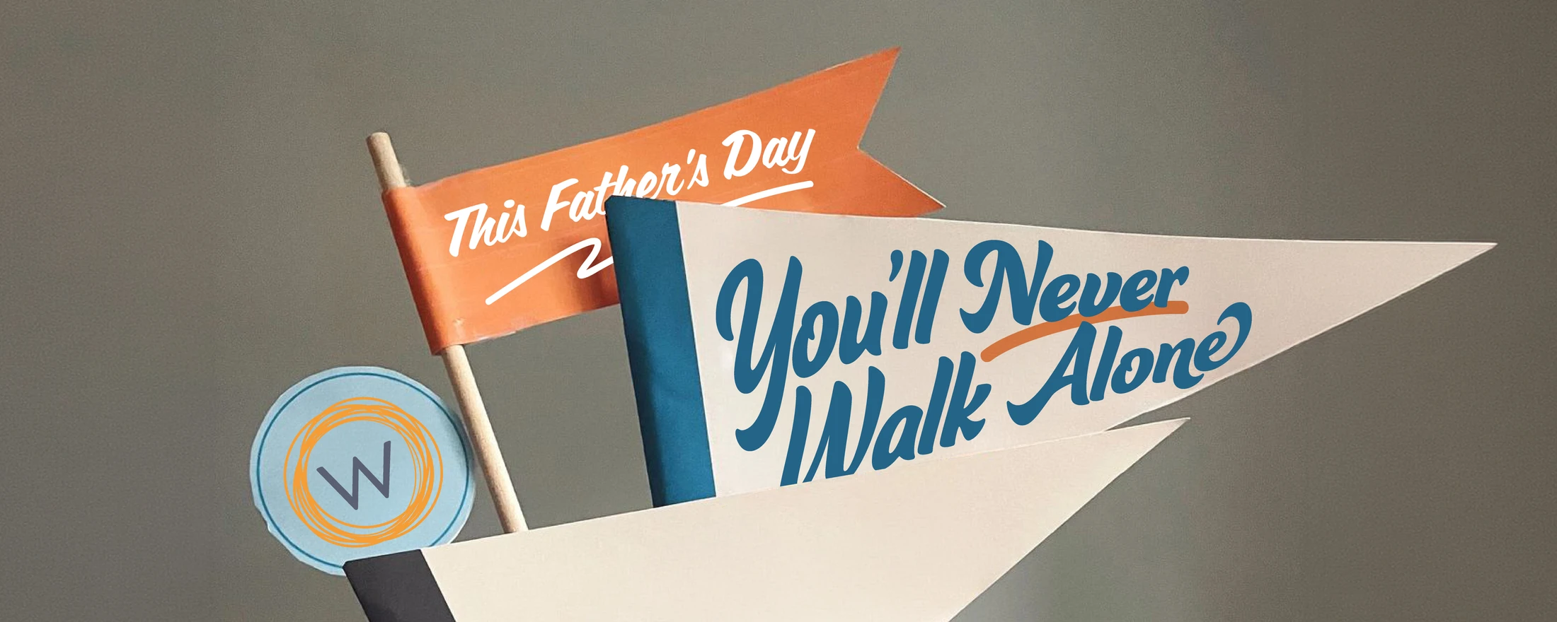 Paper flags against a gray background with Father's Day messages, including one that reads, 'You'll Never Walk Alone'.