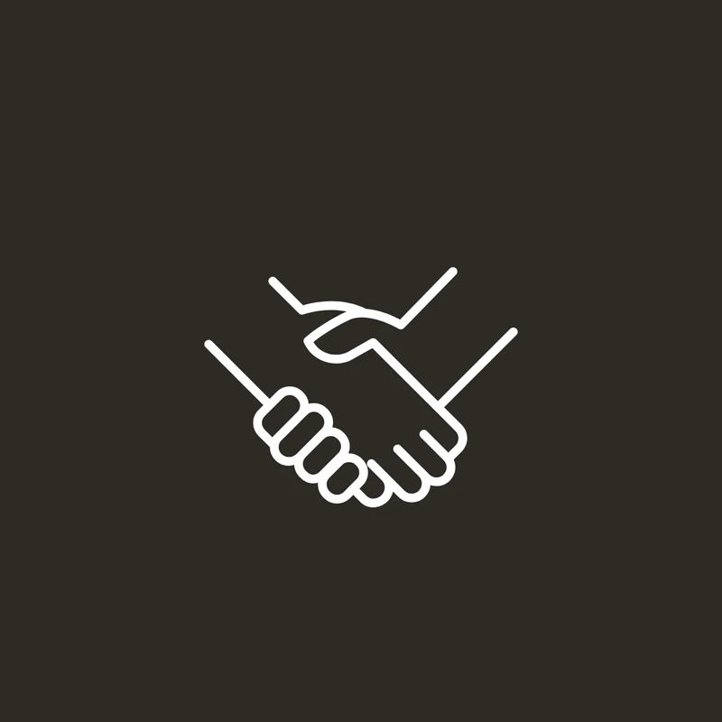A simple white line icon of two hands shaking, representing a partnership or agreement, on a dark gray background.