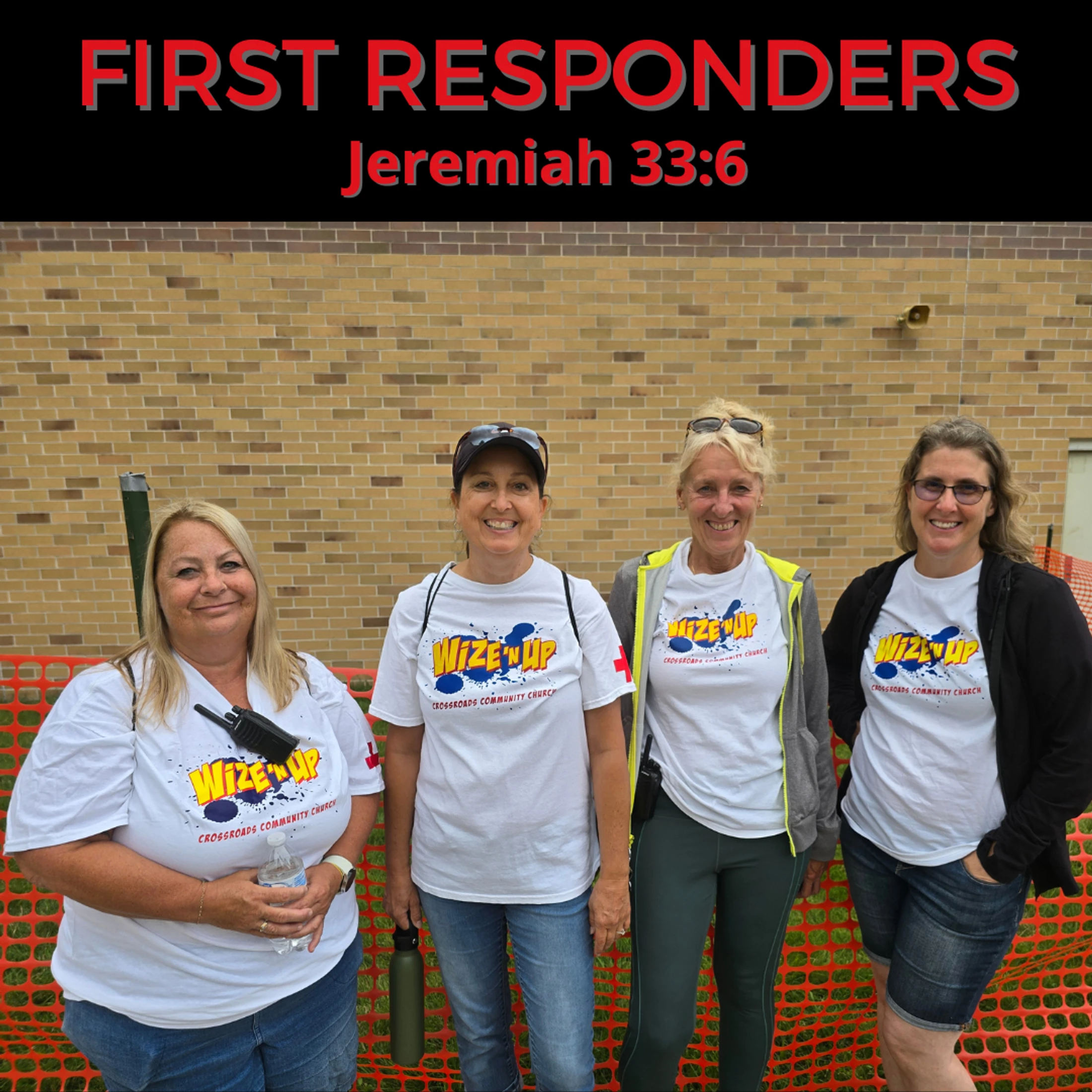 Four women from the church's first responders team smile for a group photo while wearing matching white t-shirts in front of a brick wall.