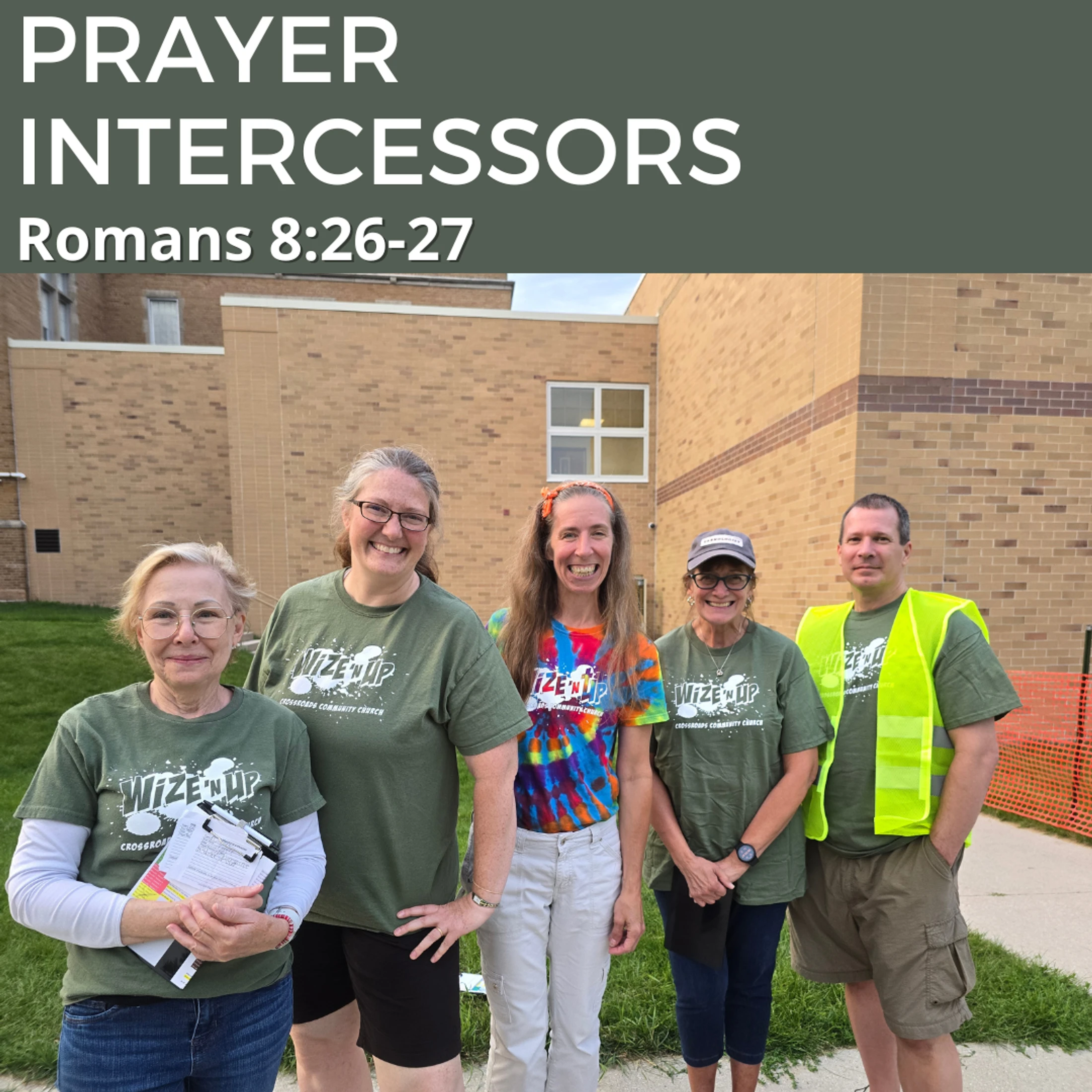 A group of five smiling church volunteers pose for a photo outside a brick building. The text overlay reads 'Prayer Intercessors, Romans 8:26-27'.