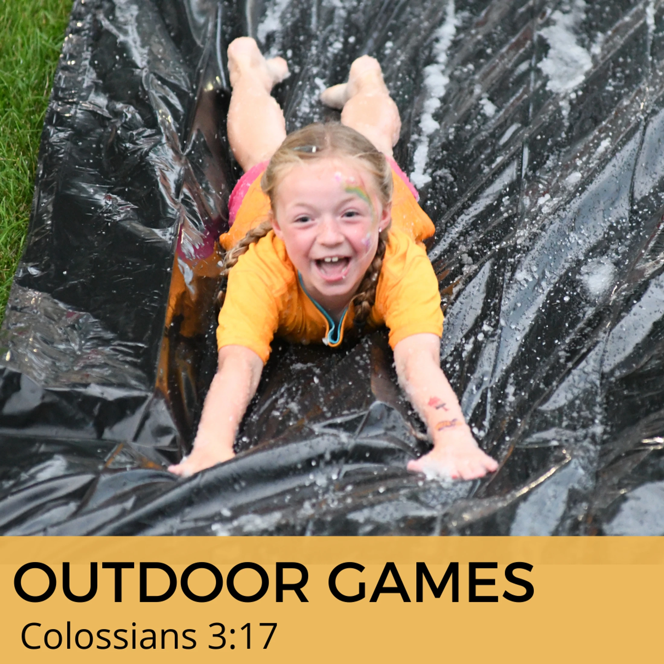 A happy young girl with pigtails and face paint slides on her stomach down a wet, black plastic sheet. Text below reads 'Outdoor Games, Colossians 3:17'.