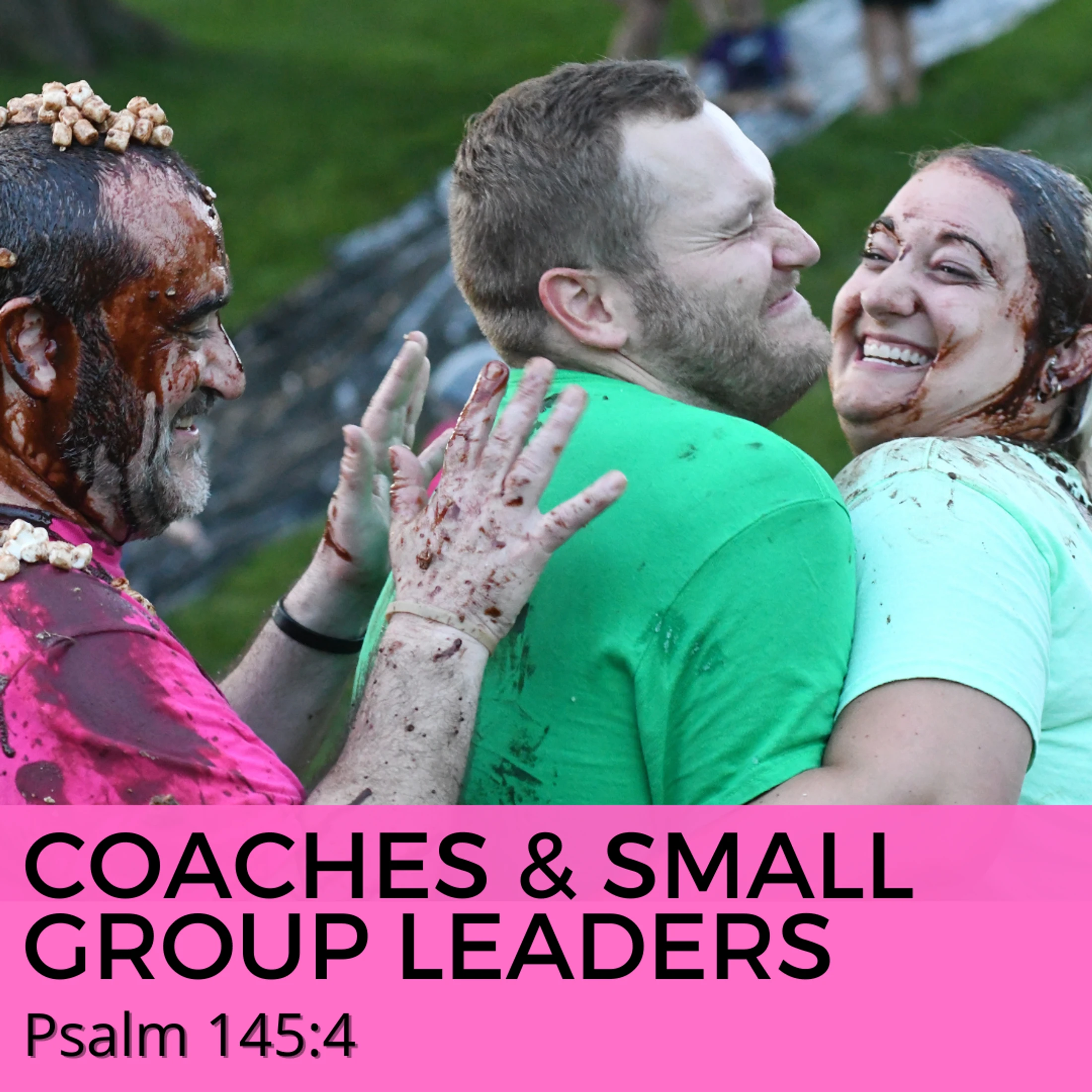 Three smiling adults covered in chocolate and marshmallows laugh and hug during a messy outdoor game, with a pink banner at the bottom.
