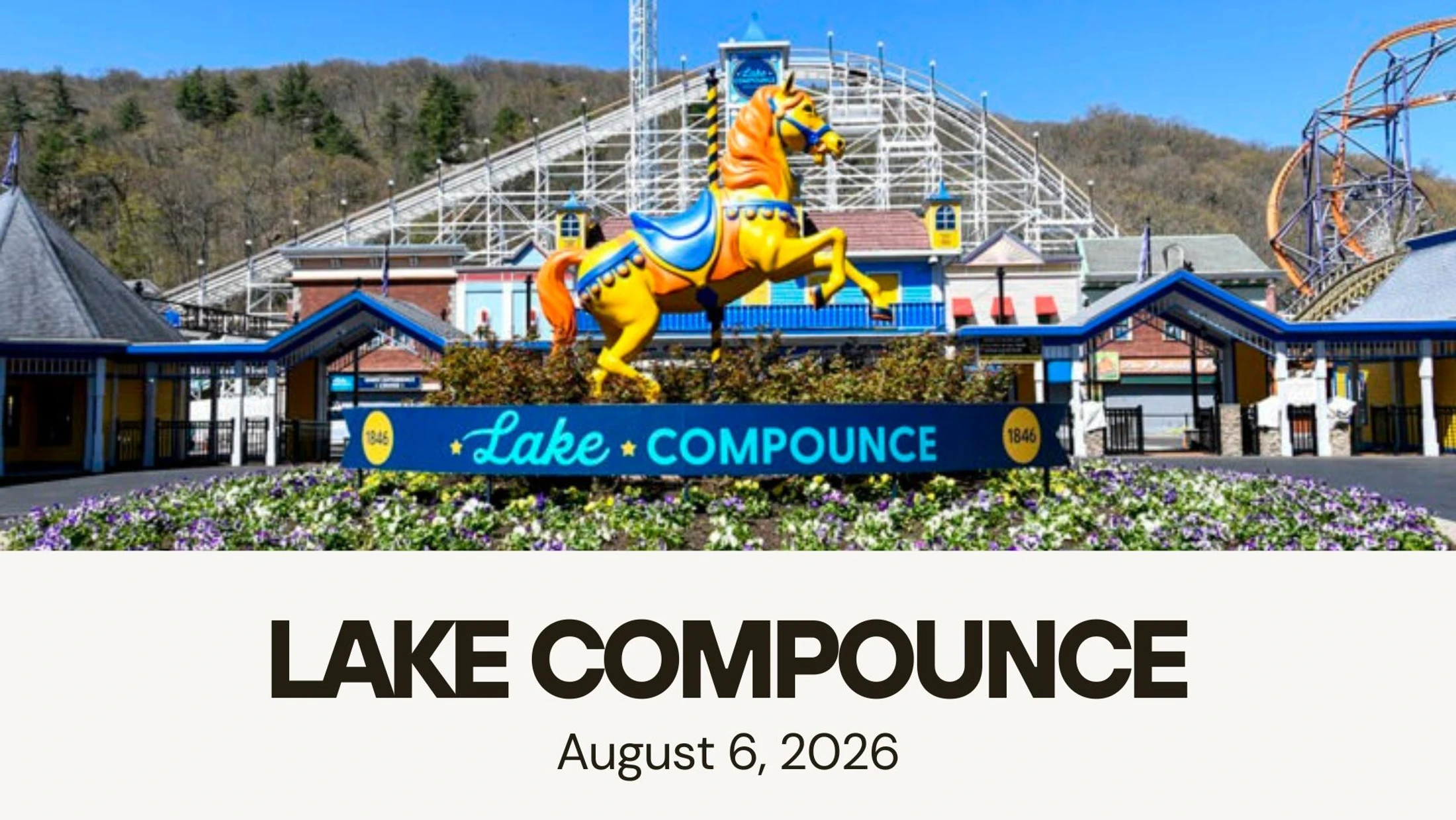 The entrance to Lake Compounce amusement park, featuring a large sign with a colorful carousel horse statue. Roller coasters are visible in the background.