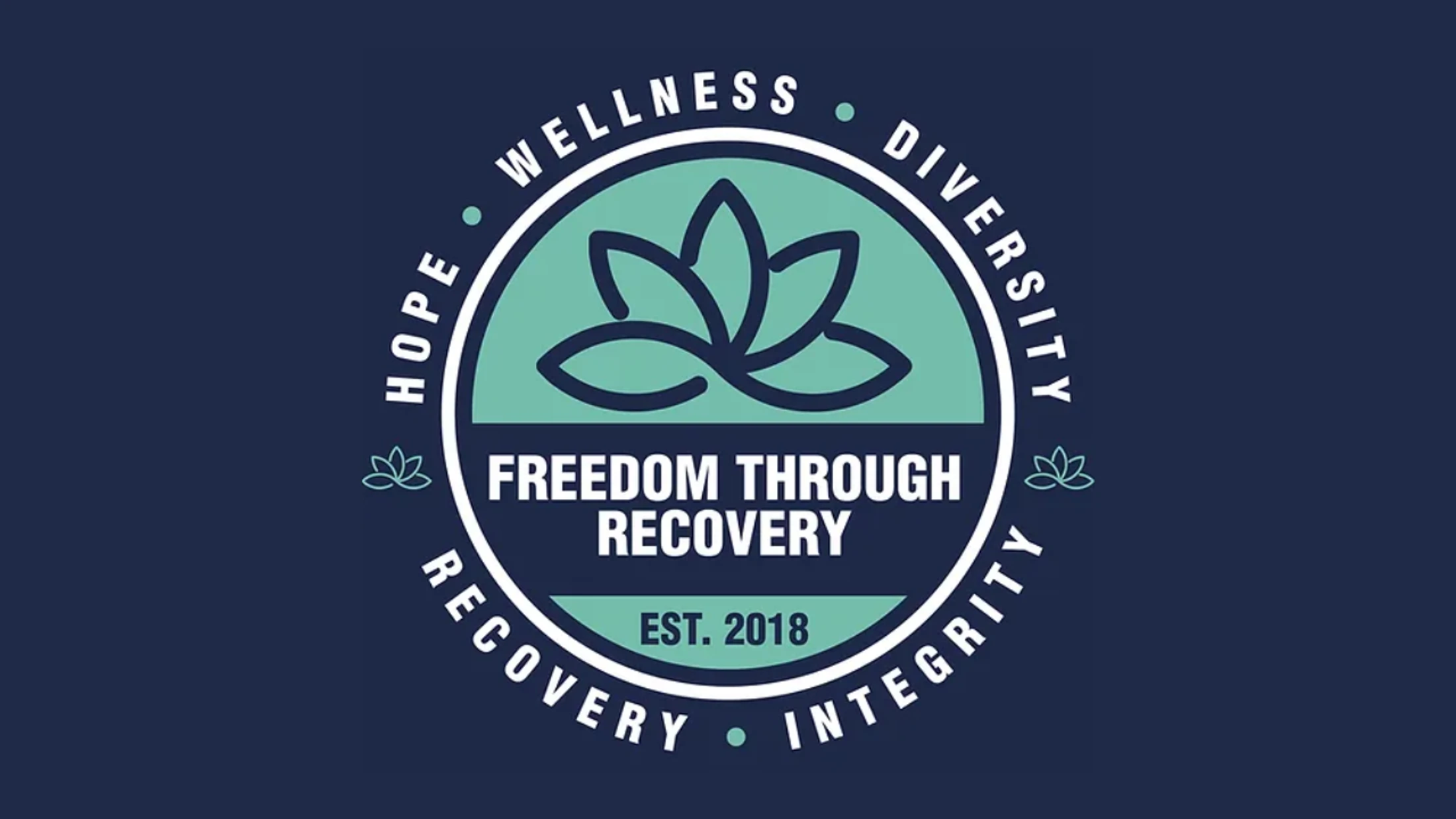 A circular logo for 'Freedom Through Recovery' with a lotus flower icon. The circle is ringed by the words Hope, Wellness, Diversity, Integrity, Recovery.