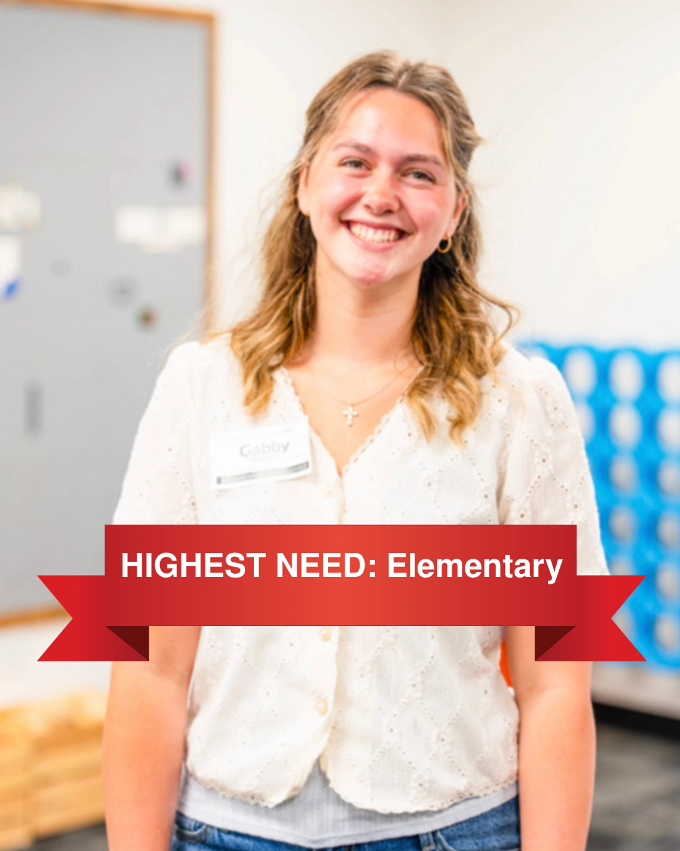 A smiling young woman named Gabby wearing a white shirt and a name tag. A red banner across the image reads 'HIGHEST NEED: Elementary'.
