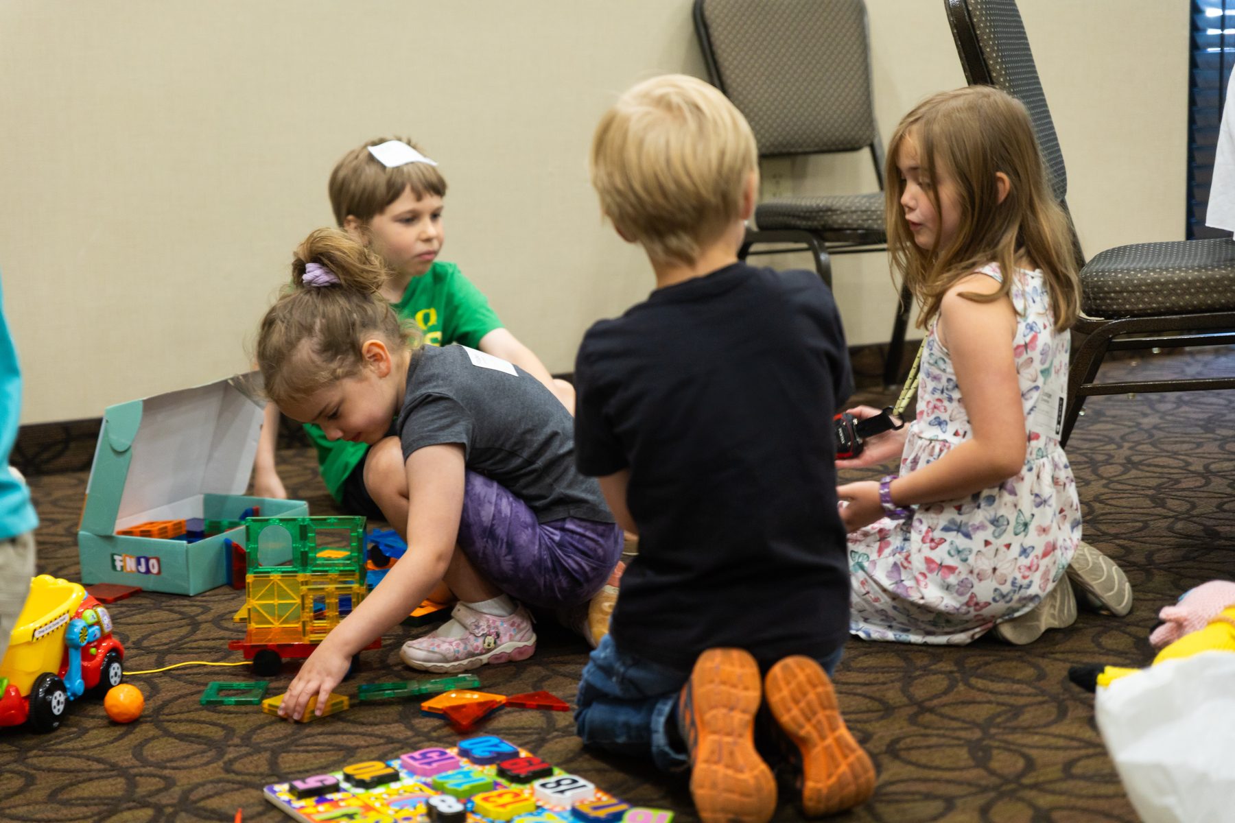 Kids playing together with a security check-in name tag visible
