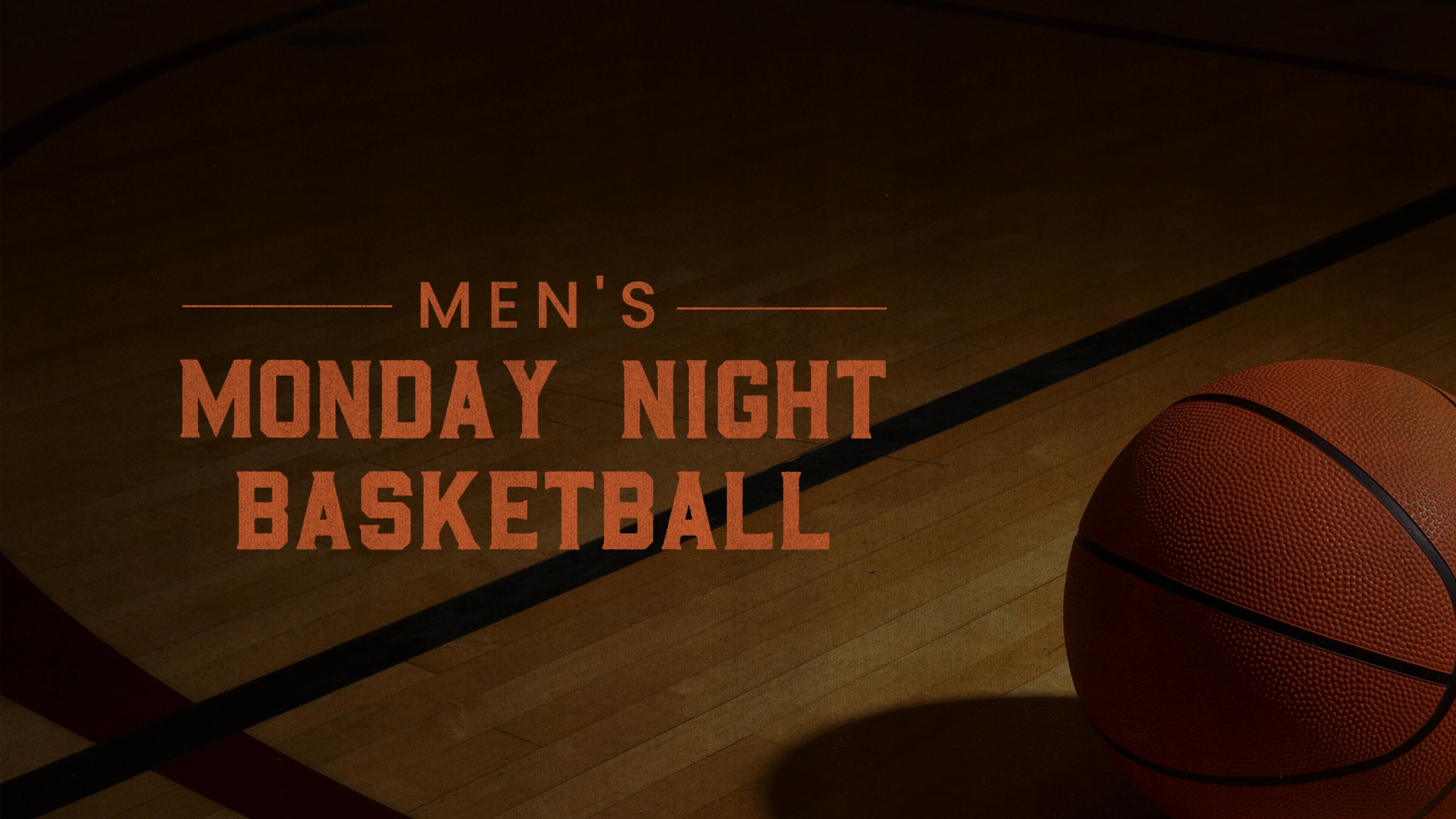 A basketball rests on a wooden court floor next to orange text that reads "Men's Monday Night Basketball".