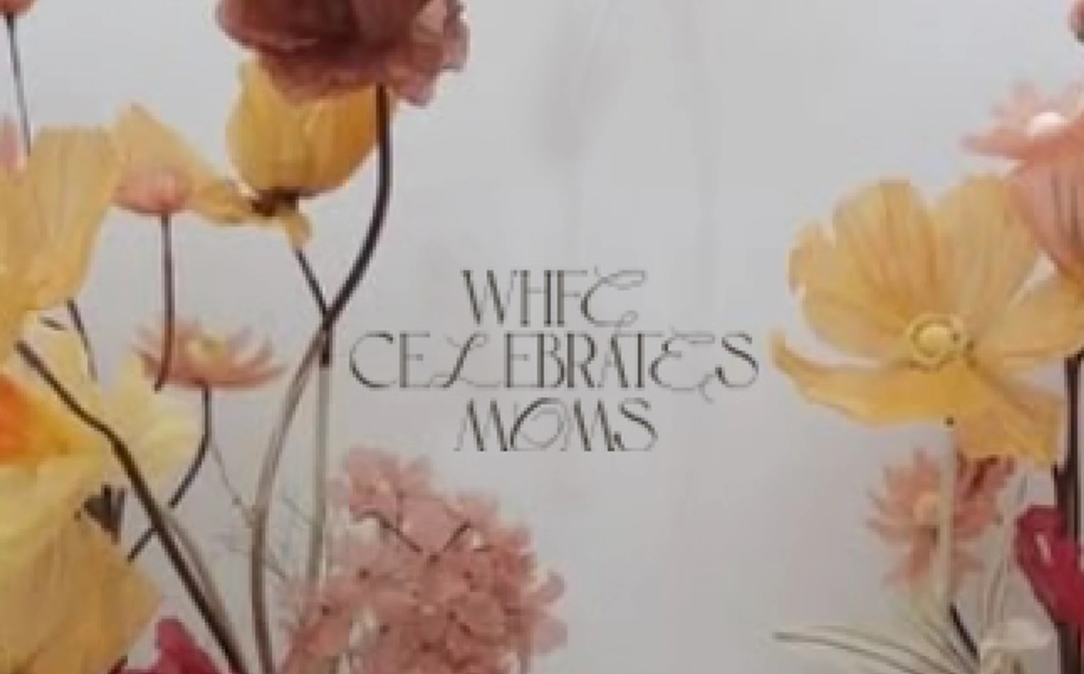A graphic with the text 'WHFC Celebrates Moms' in a decorative font, framed by delicate yellow, pink, and orange flowers against a light background.