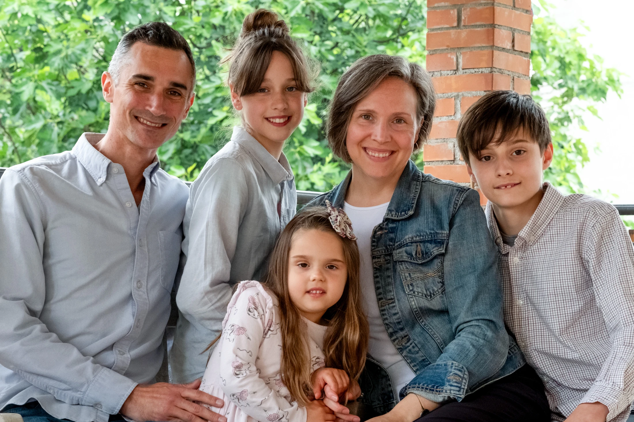 Chris and Emily Vickio with their three children smiling outdoors