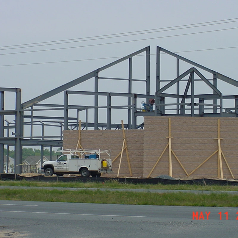 Steel frame of The Crossing church building under construction with crane and workers, May 2006