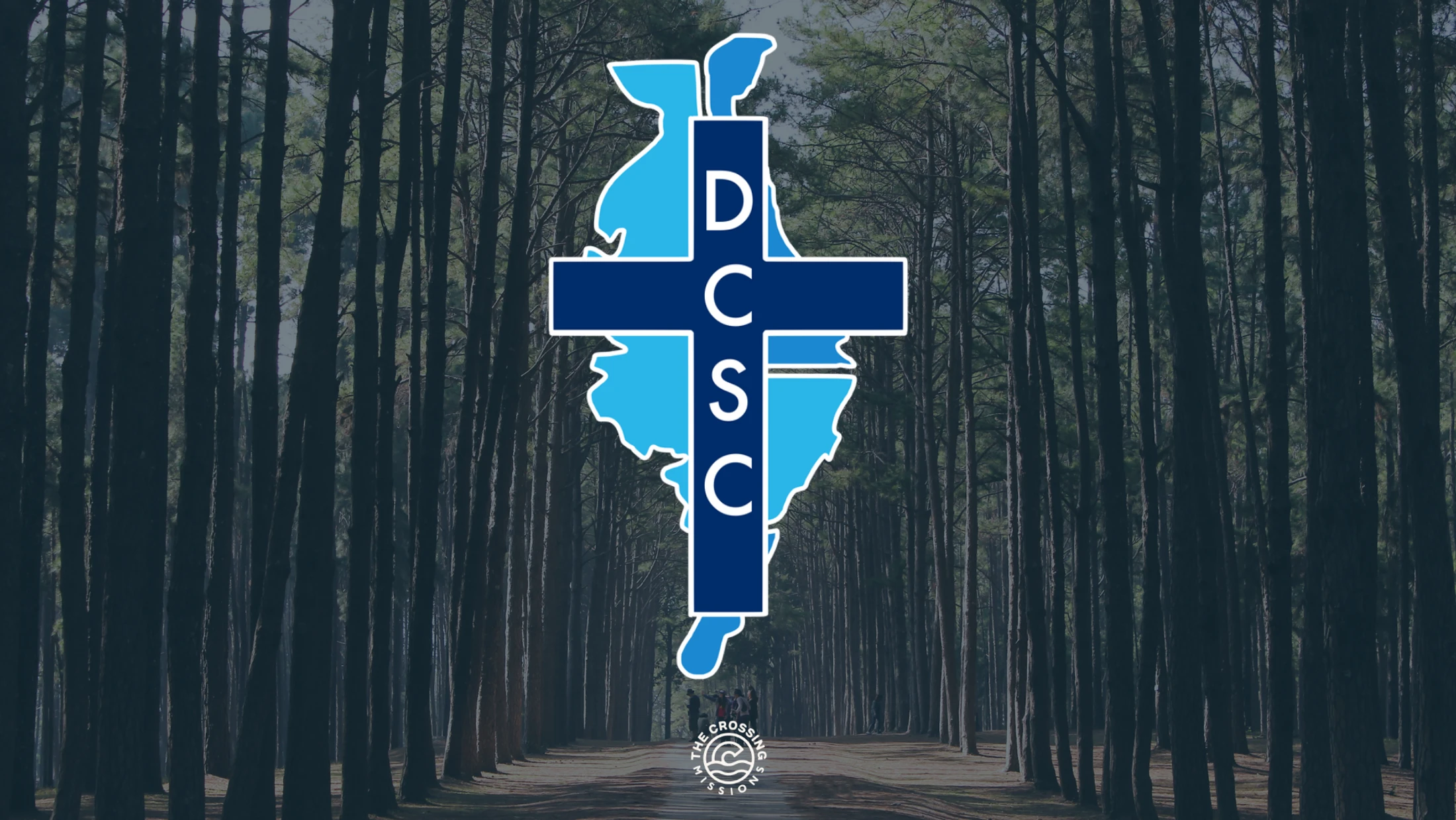 Delmarva Christian Service Camp logo over a wooded camp road.