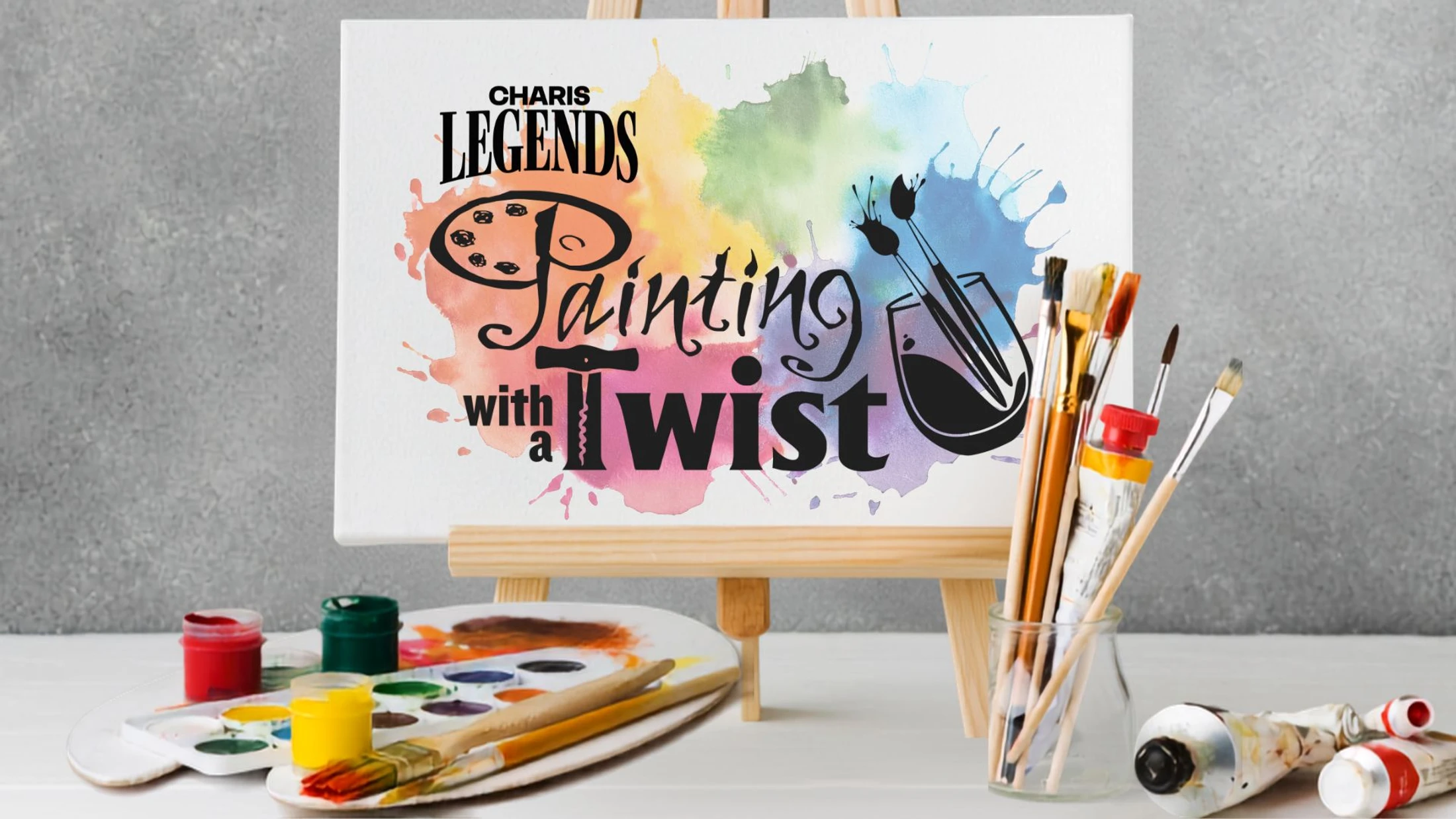 A canvas on an easel advertises a 'Painting with a Twist' event, surrounded by colorful paints, brushes in a jar, and a palette on a white table.