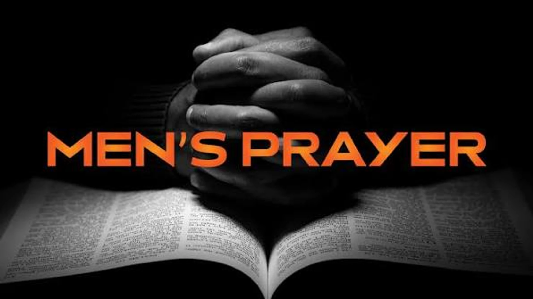 A black and white photo of clasped hands resting on an open book, likely a Bible. The words 'Men's Prayer' are overlaid in large, orange letters.