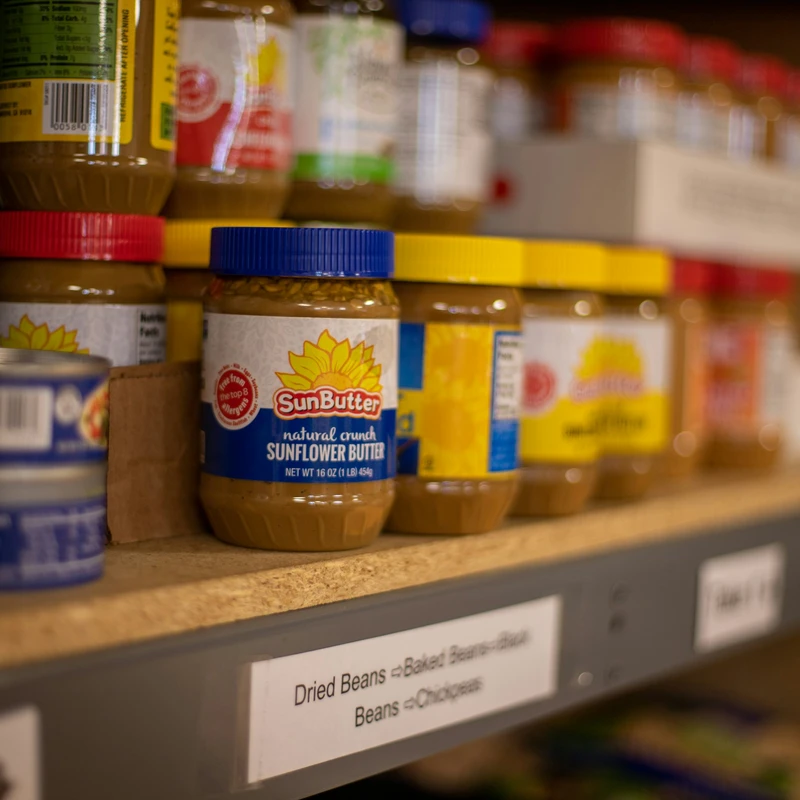 assorted plastic containers on brown wooden shelf