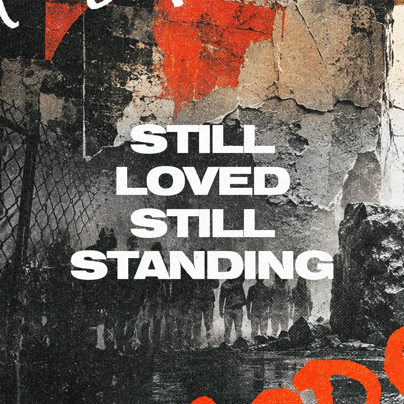A gritty graphic with bold white text reading 'STILL LOVED STILL STANDING' over a collage of a crumbling wall and silhouettes of people.