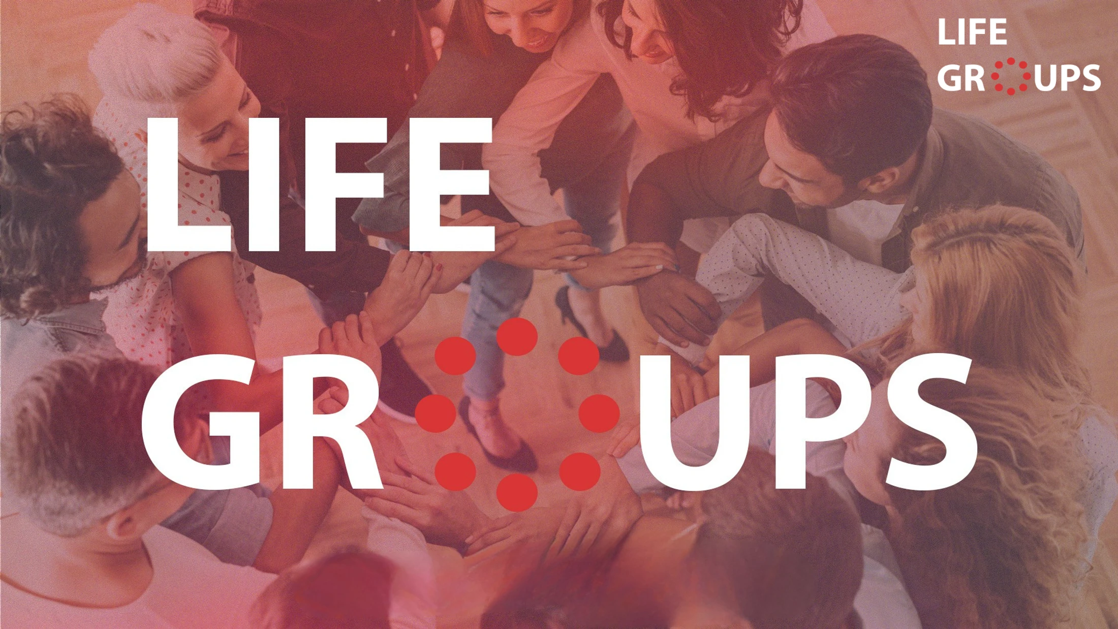 An overhead view of a group of people huddling in a circle with their hands in the center. A white text overlay reads 'Life Groups'.