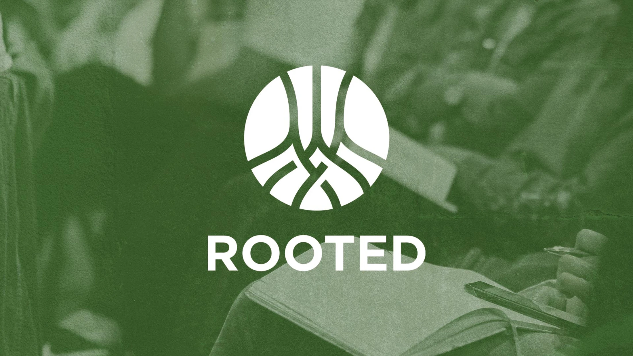 The word 'Rooted' under a white circular logo with an abstract root design, set on a textured green background showing people in a study group.