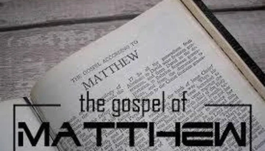 An open Bible on a wooden table, showing the first page of the Gospel of Matthew, with a graphic text overlay of the same title.
