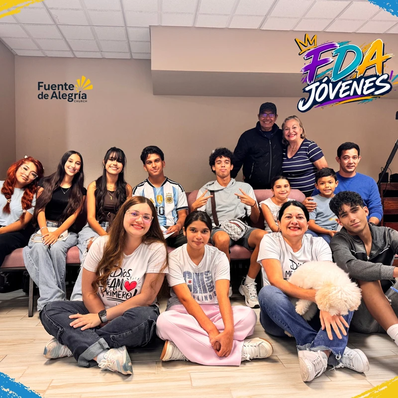 A large, diverse group of young people and adults from the FDA Jóvenes youth group smiling and posing together for a photo indoors.