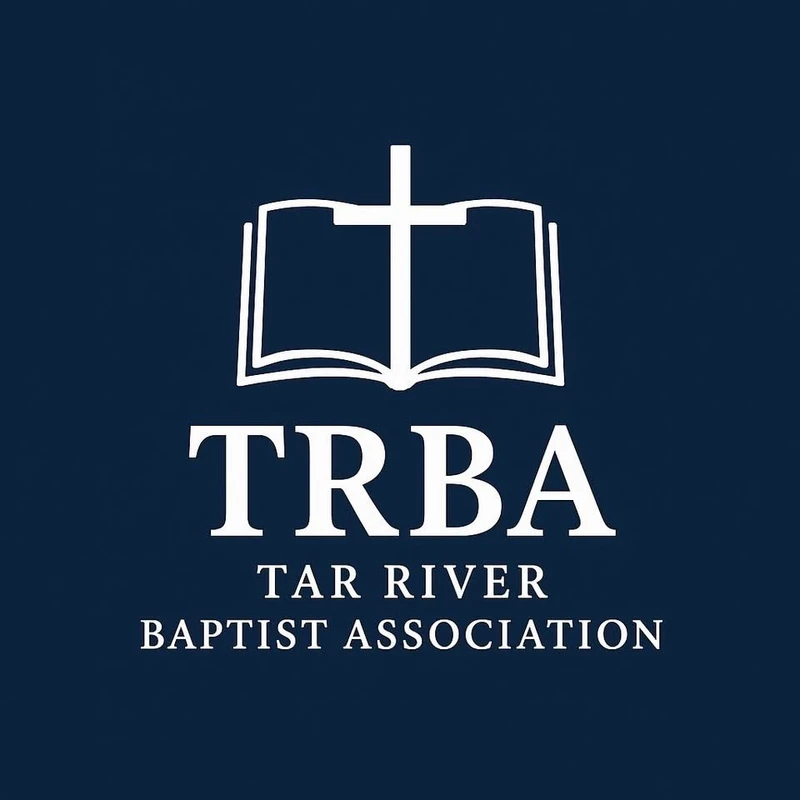 The white logo for the Tar River Baptist Association on a dark blue background, featuring a cross superimposed over an open book above the letters TRBA.