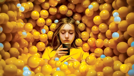 An illustration of a tired-looking young girl looking at her smartphone while sitting in a large ball pit filled with yellow smiley-face emojis.
