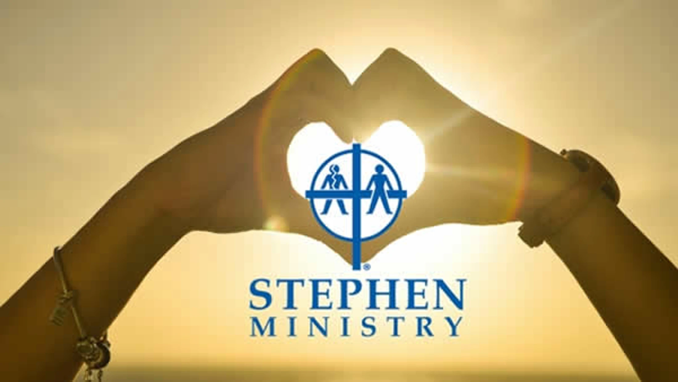 A person's hands form a heart shape against a bright sunset. In the center is the blue logo and text for Stephen Ministry.