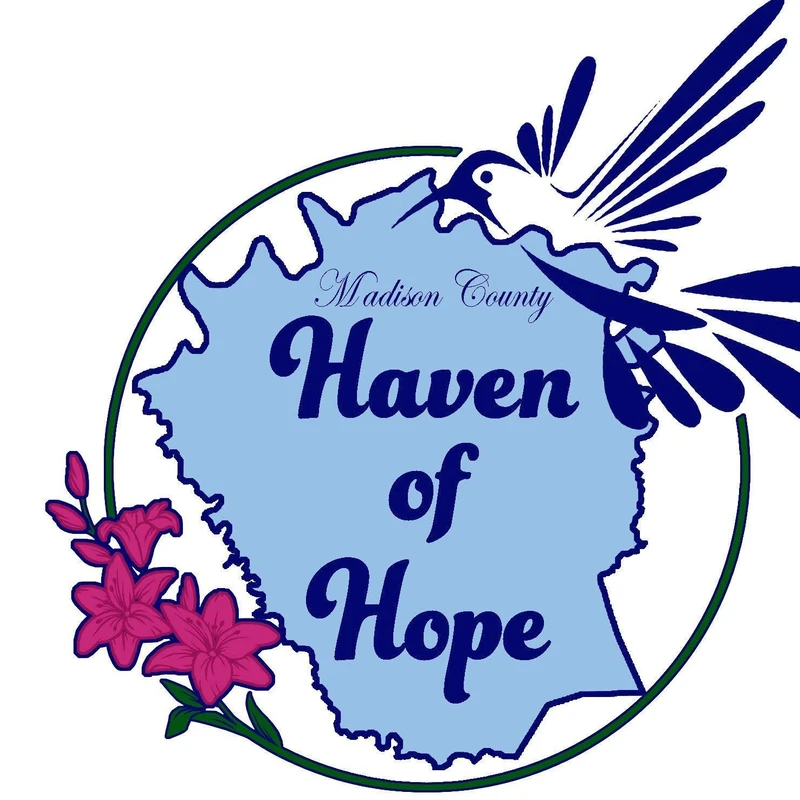 The logo for Madison County Haven of Hope, featuring a light blue outline of the county with a hummingbird and pink lilies, all within a green circle.
