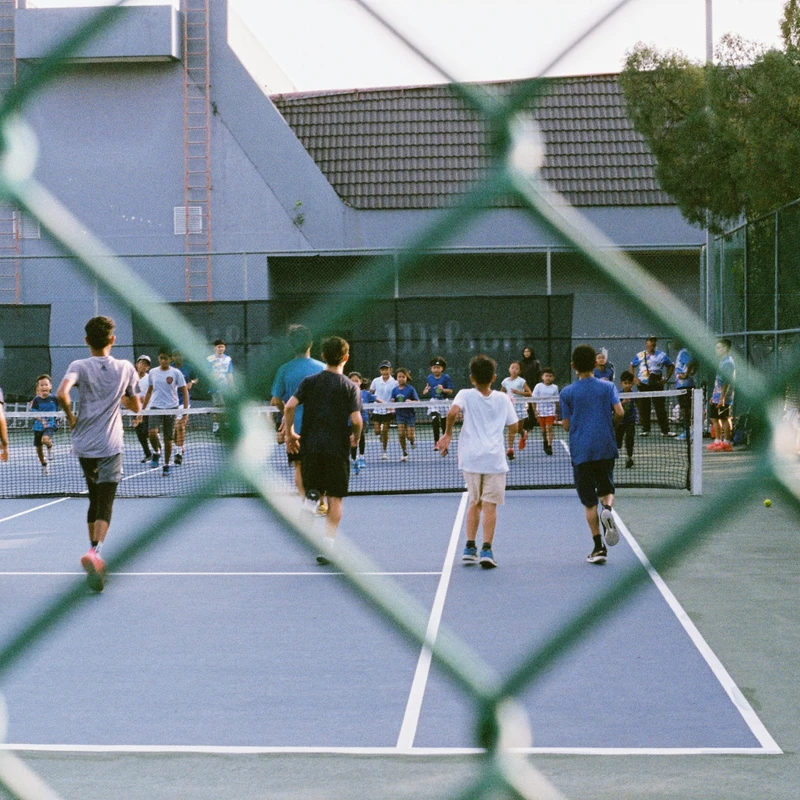 a group of people playing tennis on a tennis court